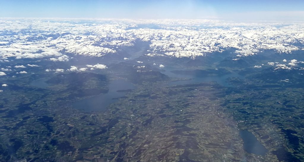 Blick auf die verschneiten Gipfel der Alpen vom Flugzeug